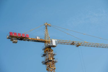 Mavi gökyüzü ile güzel bir gün ve şehrin yüksek binalarındaki kule vinci yapım aşamasında.