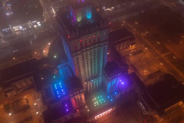 Dikkat çekici yüksek binalar Kültür ve Bilim Sarayı sisle kaplı, renkli ışıklarla aydınlatılmış, gece şehir havası manzarası