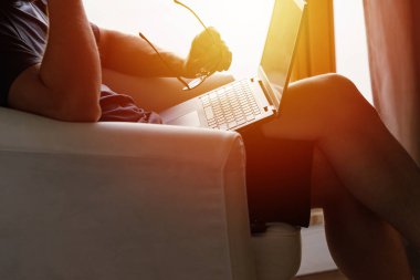 Working from home on the laptop. Wearing casual comfort outfit in home office.