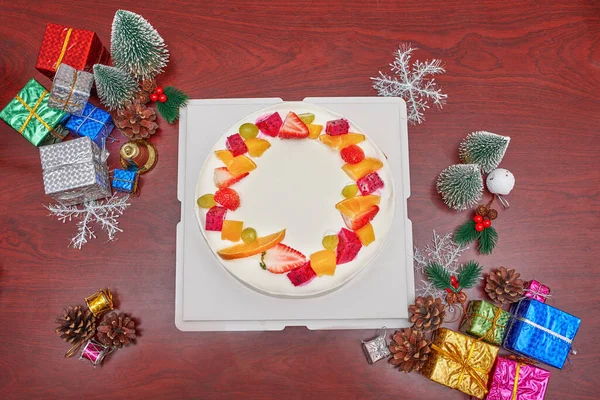 Wit Fruit Cake Omgeven Door Kerstversieringen Stockafbeelding