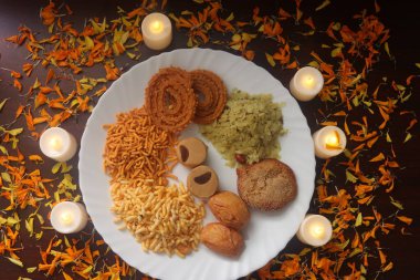 Geleneksel Hint atıştırmalıklarıyla tabak. Maharashtrian Lezzetli Atıştırmalıklar. Lambalar ve Dekorasyon. 
