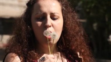 Woman Plays With Dandelon. Lovely moment and flying seeds. Summer Joy