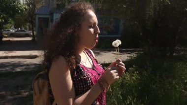 Woman Plays With Dandelon. Lovely and Funny moment and flying seeds. Summer Joy