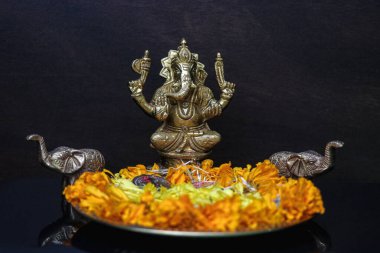Yaprak ve sikke tabağıyla Tanrı Ganesha heykeli. Hindu Ana Tanrısı ve özel bayram ve ibadet sembolü.