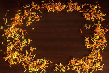 Frame with Yellow and Orange Petals of Marigold on wooden background.
