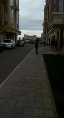 Elektrikli scooter kullanan bir kadın şehirde yürüyor.