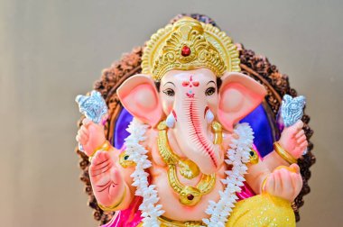 Hindu tanrısı Ganesha Fil Surat 'ı kapat. Tanrı 'nın güzel heykeli. Renkli Tanrı Ganesha. Kahverengi arka plan. Ana Hindu Tanrısı. Hinduizm Din ve Kültür.  