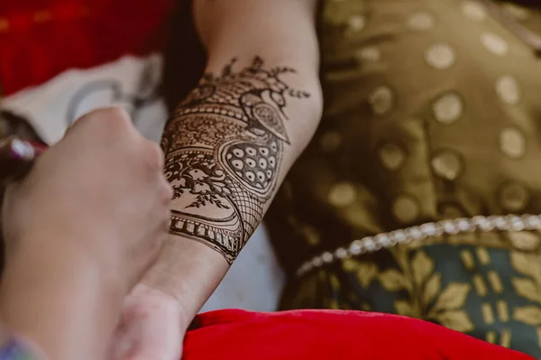 Henna tattoo on a bride hands. Elegant Brown Colors of Henna Ink. Indian Traitional Mehendi Ceremony.