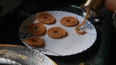 Hint geleneksel Chakkali 'si ile bir tepsiyi kapatıyoruz Kızartmaya Hazır Sıcak Yağ. Diwali Geleneksel Atıştırmalık Pişirme Süreci. Hint Geleneksel Diwali Hazırlıkları. Lezzetli Hindistan