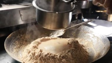 Chakkali hamuru için una kaynar su ekle. Geleneksel Hint Chakkali Hamuru yapma süreci. Hint mutfağı ve yemek pişirme anı. Parayla Çalış