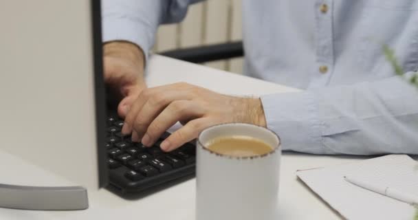 Mannelijke Handen Typen Het Toetsenbord Een Kop Koffie Tafel Een — Stockvideo