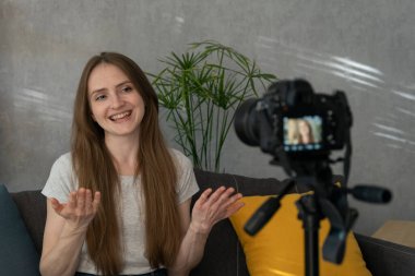Güzel gülümseyen kız bir video blogu için kendini filme çekiyor. Genç blogcu kendini kameraya çekiyor. Popüler hobi.