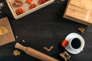 Cadılar Bayramı yemeği konsepti. Lezzetli portakallı kurabiye ve bir fincan sade kahve. Yazı için koyu arkaplan. 