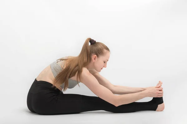 Esneme Egzersizleri Genç Bir Kadın Beyaz Arka Planda Yoga Yapıyor — Stok fotoğraf