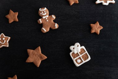 Siyah arka planda zencefilli çöreğin hediye kutusu ve yıldızları. Geleneksel hamur işleri.