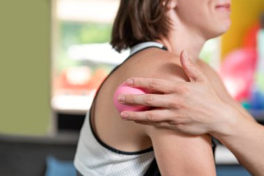 Genç sporcu kız miyofasyal topla masaj yapıyor. Köpük silindirli miyofasyal salınım. Kendi kendine masaj.