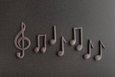 Üç boyutlu notalar ve siyah arkaplanda üç boyutlu anahtarlar. Müzik notaları. Müzik sembolü