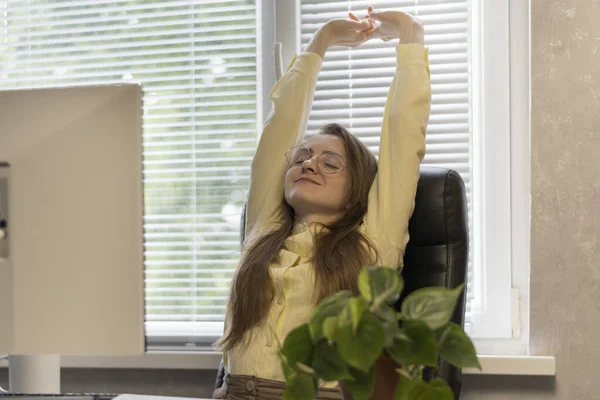 Молодая Женщина Приятно Улыбается Поднимая Руки Вертикально Сидя Рабочем Месте — стоковое фото