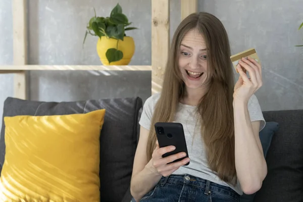 Happy Young Woman Holding Phone Credit Card Sitting Couch Online — Stock Photo, Image