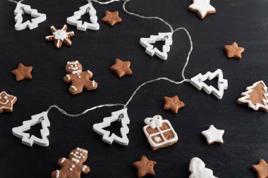 Noel kurabiyesi adam, yıldızlar ve siyah arka planda köknar ağacı. Üst görünüm.