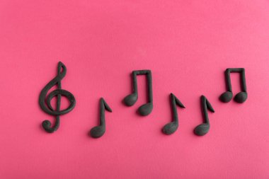 Pembe arka planda üç düğmeli anahtar ve notalar. Müzik sembolü. Sol anahtarı. Keman anahtarı. Müzik gösterimi
