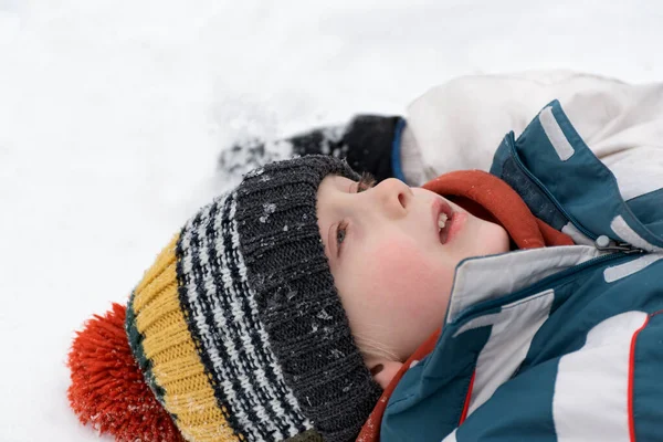 Portrét Chlapce Ležícího Sněhu Hledícího Nebe Dítě Hlavě Pestrobarevný Pletený — Stock fotografie