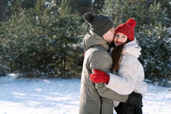 快乐的情侣们在冬天的森林里 在白雪覆盖的冷杉的背景下坠入爱河 — 图库照片