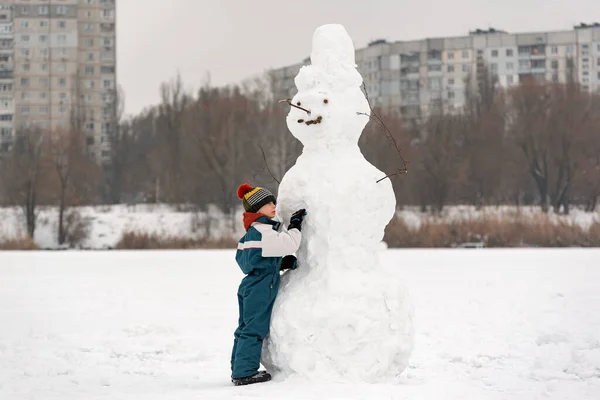 Portrait Little Boy Huge Snowman Child Sculpts Snowman Snowy Winter — Stock Photo, Image