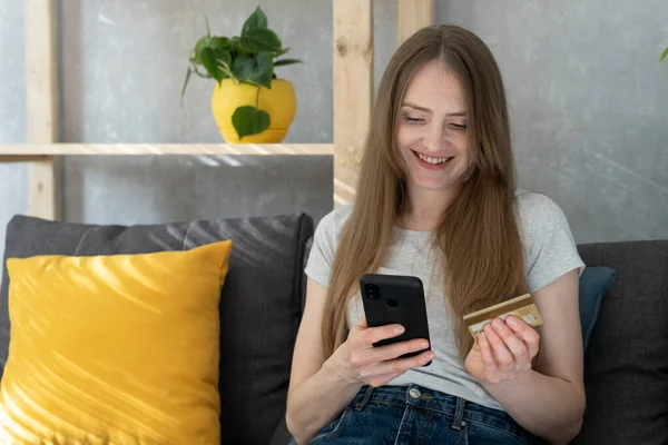 Happy Young Woman Holding Phone Credit Card Sitting Couch Online — Stock Photo, Image