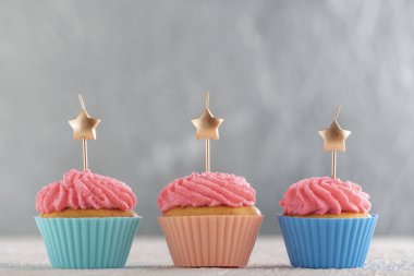 Pembe kremalı ve mumlu lezzetli kekler. Fotokopi alanı olan lezzetli kekler. Gümüş arkaplan.