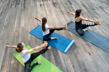 Üç kız dışarıda yoga yapıyor. Sabah yoga antrenmanı. Açık hava fitness. Sağlıklı yaşam tarzı