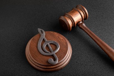 Müzik sembolü anahtar ve yargıç tokmağı siyah arka planda. Müzik korsanlığı ve telif hakkı ihlali