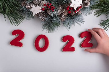 Zencefilli kurabiyeden 2022 yazıtları, kurabiye alan çocuk eli. Yeni yıl ve Noel dekoru.