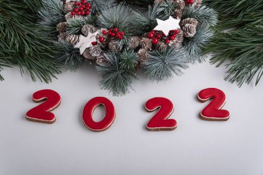2022 yazıtları ve Noel çelengi, üst manzara. Beyaz arka plan. Mutlu yıllar 2022.
