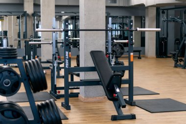 Antrenman için çeşitli ekipmanları olan modern spor salonu. Spor simülatörleri ve dambıllar
