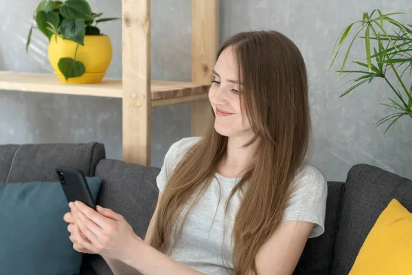 Die Junge Frau Hält Ihr Handy Der Hand Blickt Auf — Stockfoto