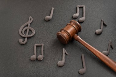 Hakimler üç katlı anahtarla ve siyah arkaplandaki notlarla çevrili. Müzik lisansı ve telif hakkı ihlali. Müzik korsanlığı