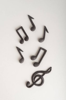 Kaotik olarak düzenlenmiş üçlü anahtar ve beyaz arka planda notlar. Müzik sembolü. Dikey çerçeve.
