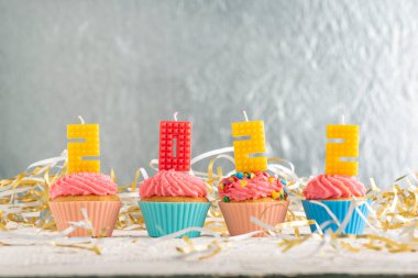 Kekler renkli 2022 mum numarasıyla dekore edilmiş. Mutlu yıllar teması. Kutlama kekleri.