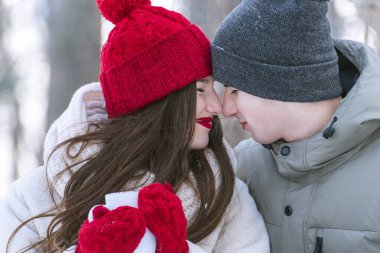 Dışarıda örgü şapkalı mutlu genç bir çift. Sevgililerin portresi.