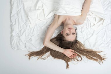 Genç kız yatakta uyuyor, manzarası çok güzel. Sabah uyandıktan sonra güzel bir kadının portresi.