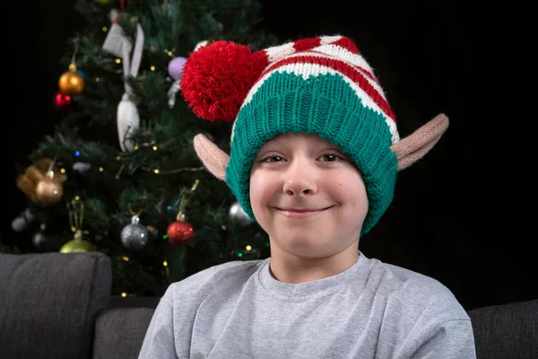 크리스마스 모자를 소년의 초상화 크리스마스 트리의 배경에 — 스톡 사진