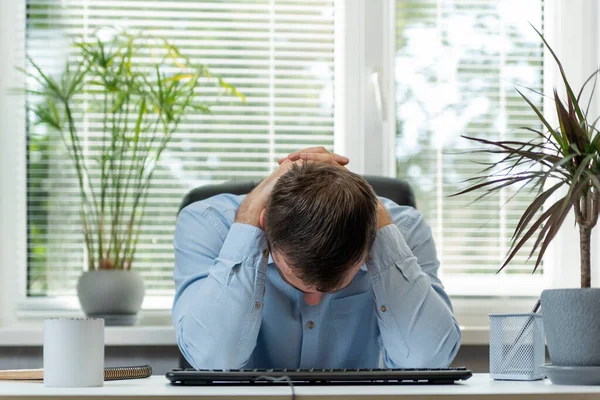 事務所の若い男は頭をがむしゃらに下げた 仕事中の問題 バーンアウト症候群 正面図 — ストック写真