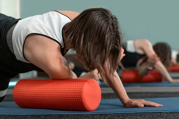 Woman using massage tool for myofascial therapy on hands and shoulder blades. Equipment for myofascial release