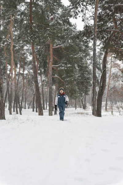 Αγόρι Χειμερινή Φόρμα Και Πολύχρωμο Καπέλο Βγαίνει Καλυμμένο Χιόνι Δάσος — Φωτογραφία Αρχείου