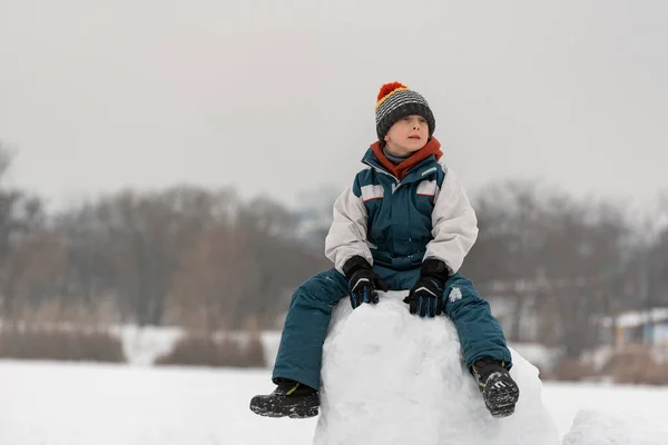 Усміхнений Хлопчик Семи Років Сидить Сніговій Вежі Дитина Будує Сніговий — стокове фото