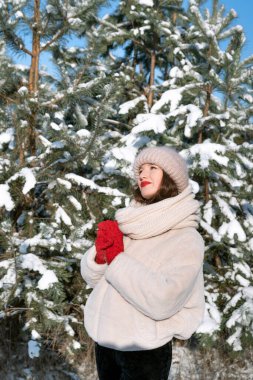 Young woman near snow-covered trees. Vertical frame