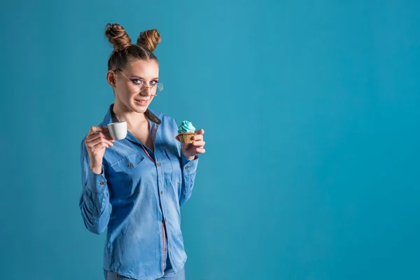 Attractive Girl Wears Blue Shirt Glasses Holds Cupcake Cup Espresso — Zdjęcie stockowe
