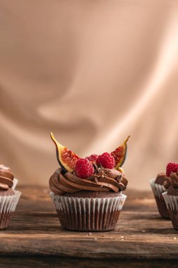 Mevsimlik böğürtlenler ve ahşap masada meyvelerle süslenmiş çikolatalı pasta. İncir ve ahududulu ev yapımı kek.