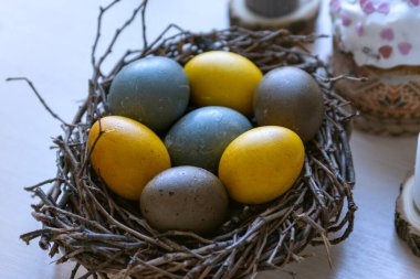 Paskalya kompozisyonunu kuş yuvasında çok renkli yumurtalarla ve masada Paskalya pastasıyla kapat.